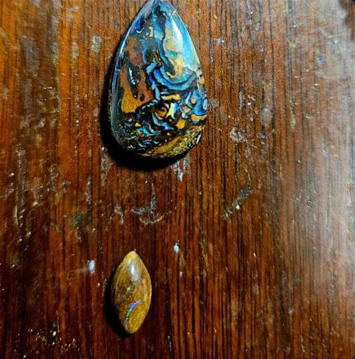 Teardrop-shaped opal on a wooden surface