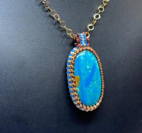 Necklace with a blue pendant on a dark background